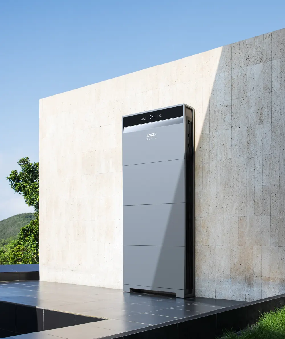Anker SOLIX X1 home battery installed against a stone wall with hills behind